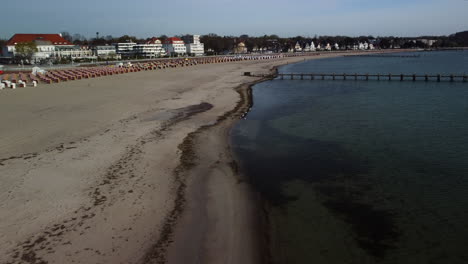 Flight-over-an-empty-beach-with-a-neglected-bridge-in-the-background