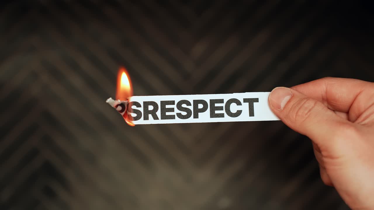 Hand burns paper strip labeled DISRESPECT, symbolizing toxic behavior, broken trust, and setting boundaries, with copy space on dark background