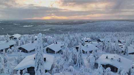 aerial view around a snowy tree in a cottage village, high in the fells of lapland