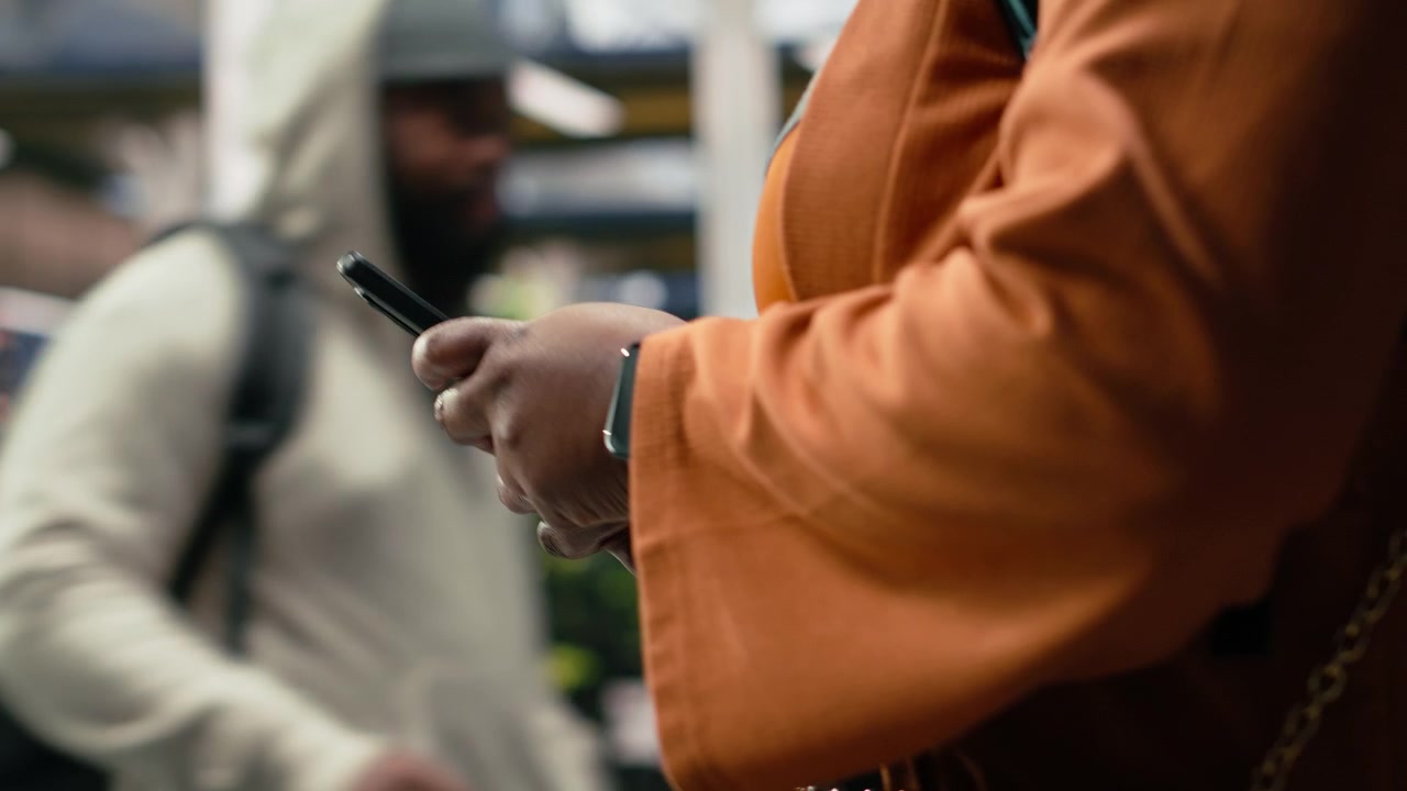 Close up of traveler holding phone, looking up bus schedule on internet
