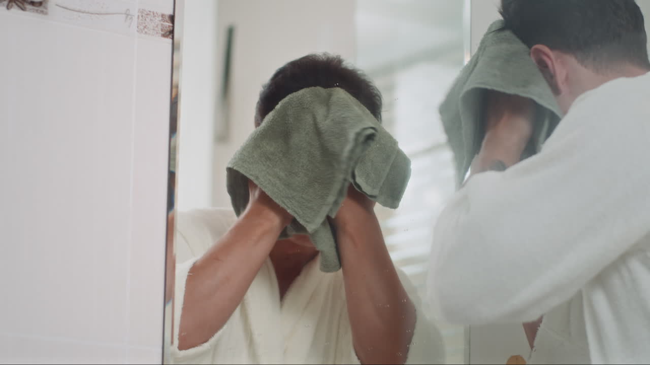 Young Man Using Towel to Wipe Face after Washing