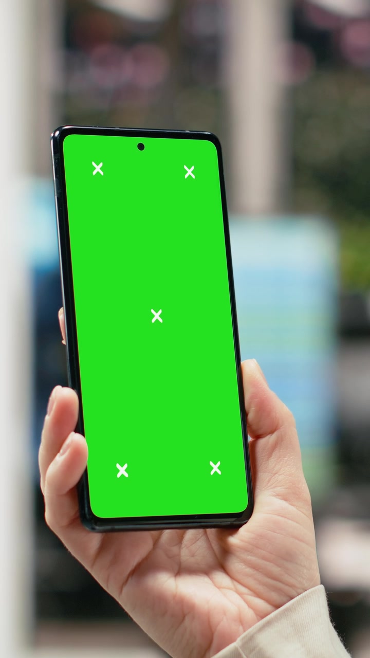 Video verticale: Smartphone con schermo verde utilizzato da una donna in un nodo di trasporto.