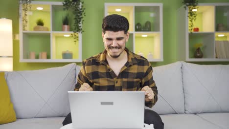 y un joven nervioso esperando mirando la computadora.