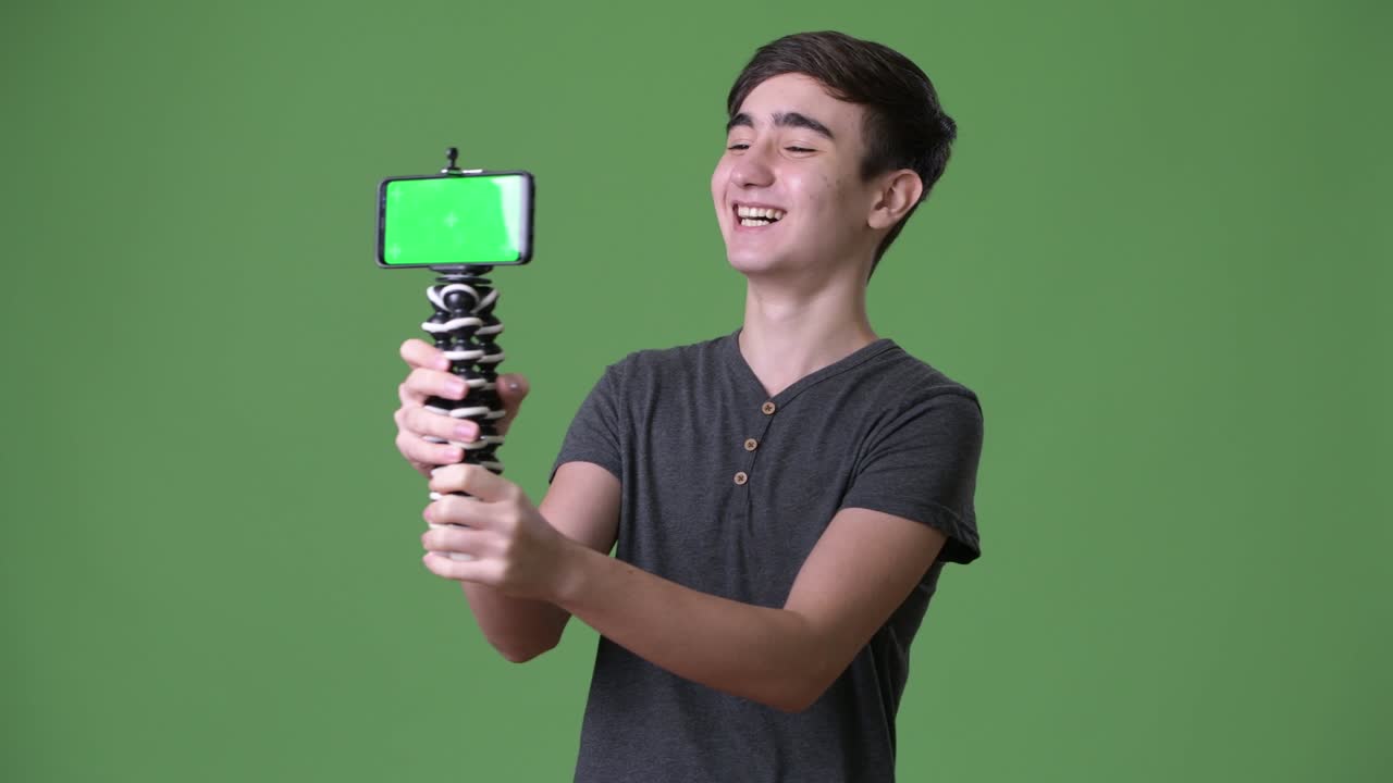 초록색 배경에 젊은 잘생긴 이란 십대 소년