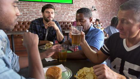 Grupo-De-Amigos-Varones-Comiendo-En-El-Bar-De-Deportes-Rodada-En-R3d