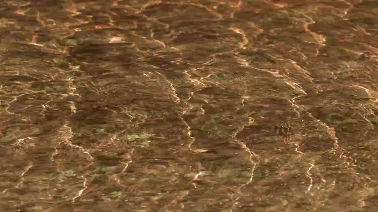 Close-up of rippling water flowing over a sandy riverbed in the Blue Mountains, Australia.