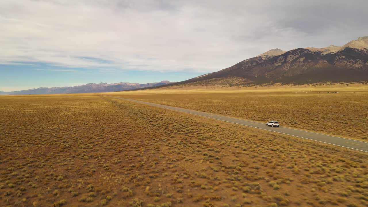 산 뒤쪽 도로를 따라 운전하는 자동차 해가 지는 공중 촬영 4k