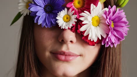 close-up of a person with a colorful flower crown covering their eyes