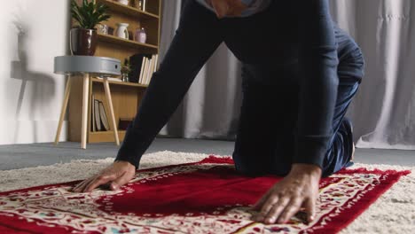 mujer musulmana usando hijab en casa arrodillada sobre una alfombra de oración y orando 2