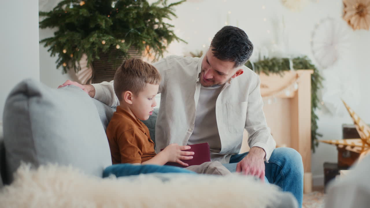 el padre anima al hijo a leer un libro