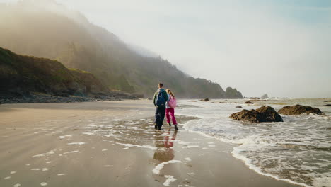 couple walking along a misty coastal beach