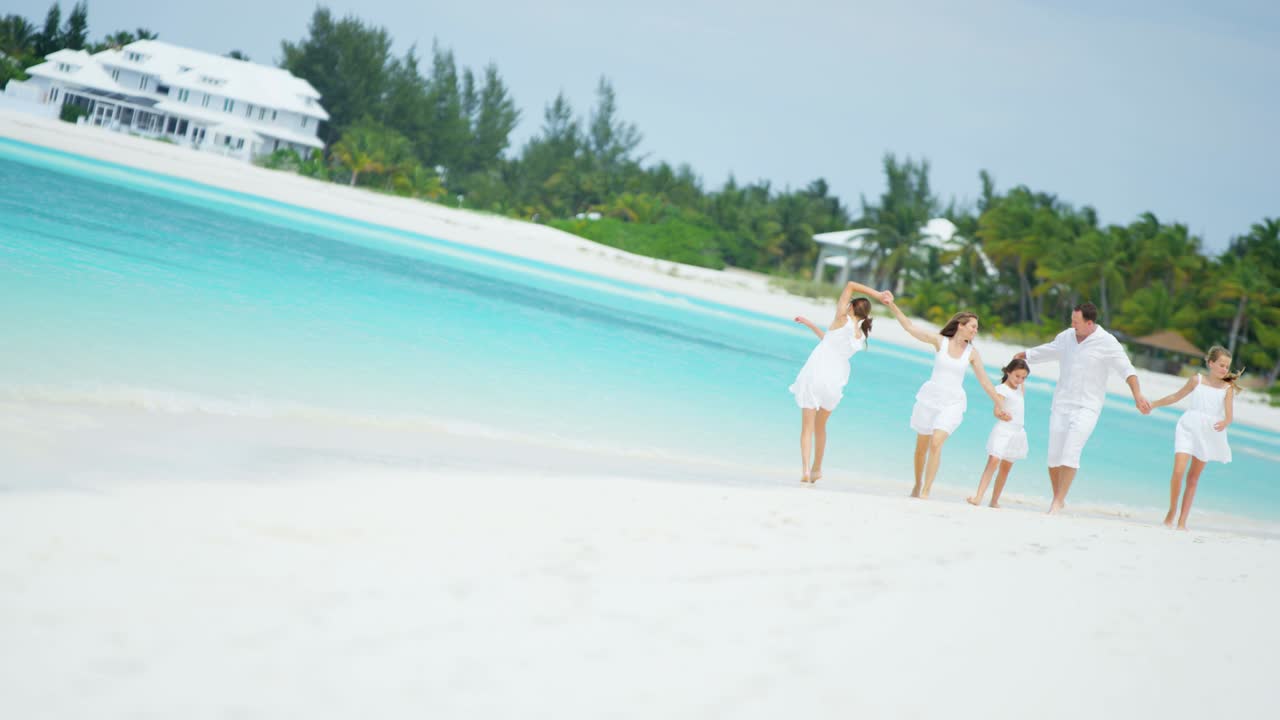 Caucasian parents and their young daughters on beach