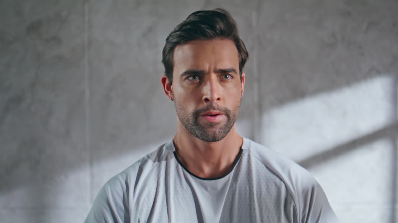 Focused man exercising weight plate in loft studio closeup. Man training hands