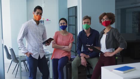 portrait of diverse colleagues wearing face masks at modern office