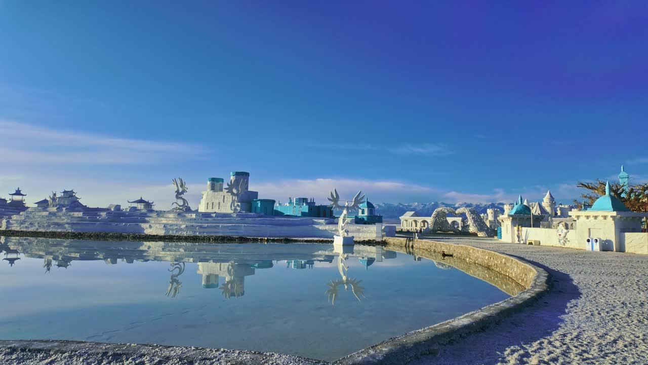 Chaka Salt Lake, Qinghain maakunta, Kiina – Surrealistinen valkosininen arkkitehtoninen kokonaisuus seisoo yksin valtavalla suola-aavikolla kirkkaan, syvän sinisen taivaan alla – panorointi oikealle
