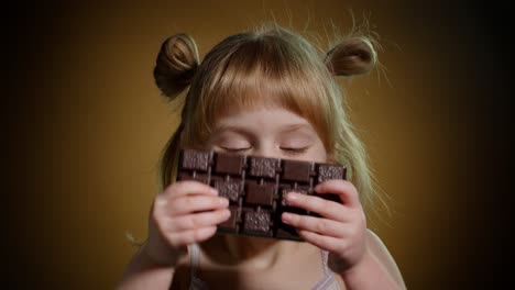 Close-up-portrait-of-teen-child-kid-girl-eating-milk-chocolate-bar,-addiction-of-sweets-and-candies