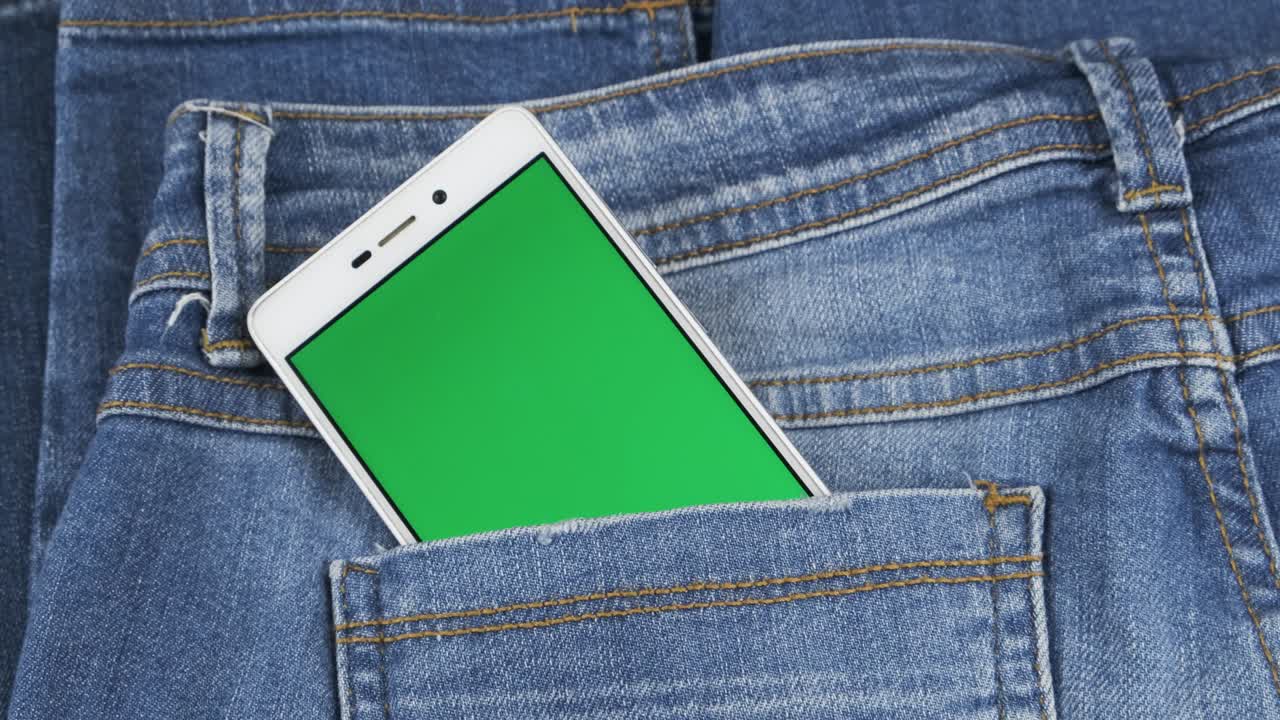 el panorama de un teléfono que sobresale de un bolsillo de vaqueros. pantalla chromakey.
