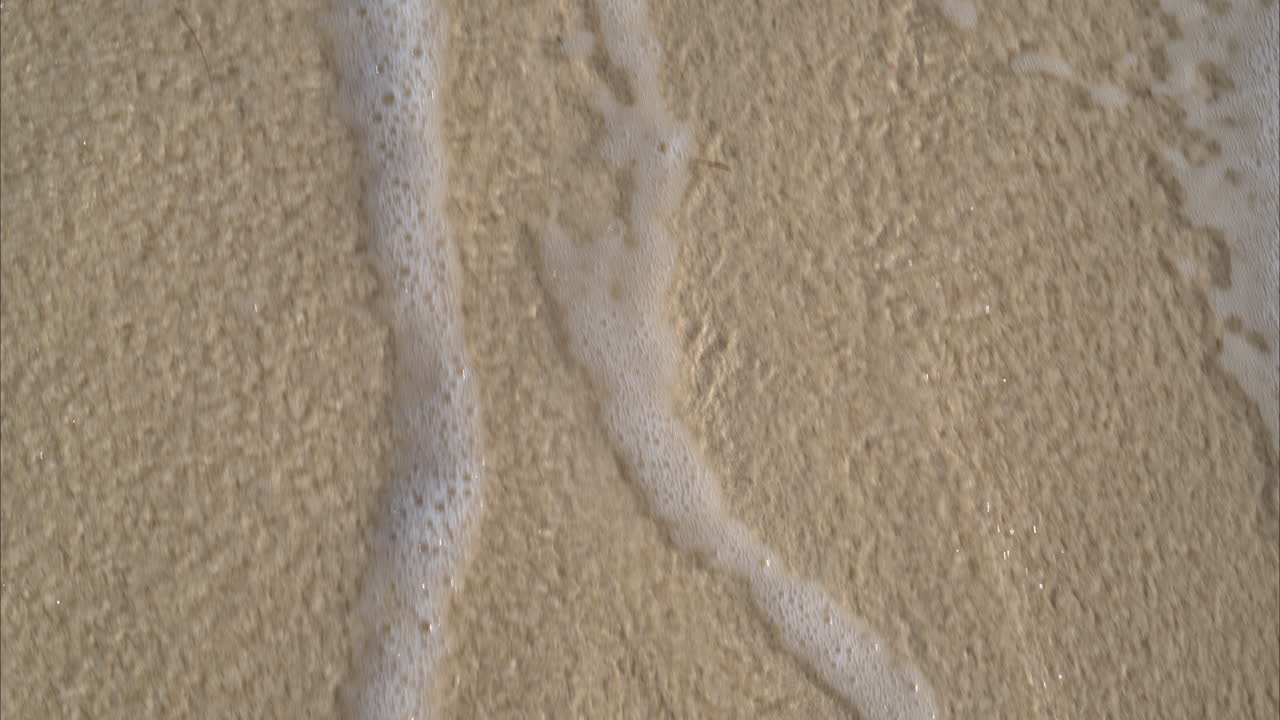 슬로우 모션은 거품과 함께 해변으로 들어오는 물을 닫고 잔잔한 방식으로 파도와 함께 거품을냅니다.