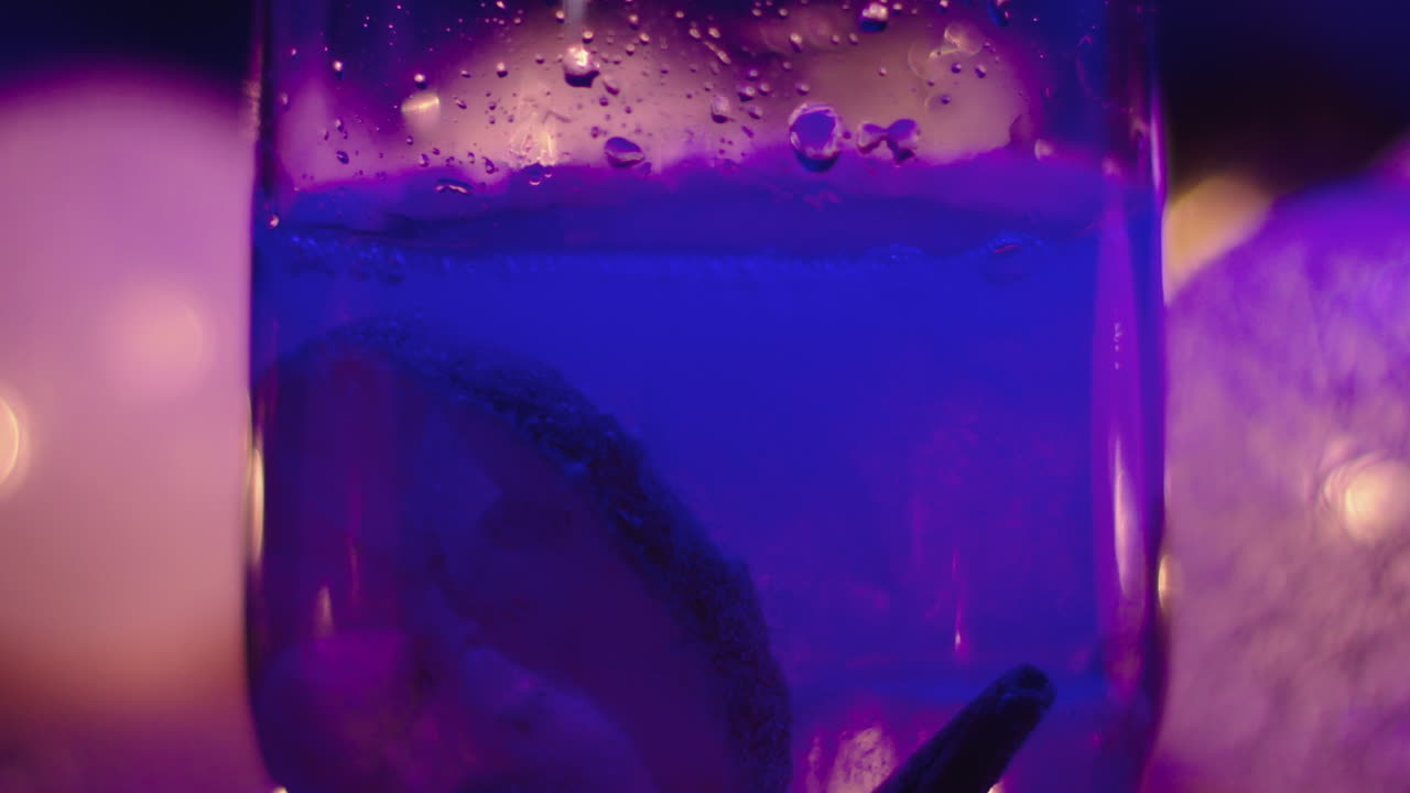 primer plano de bloques de hielo cayendo en un vaso lleno de una bebida tónica