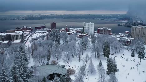 Sobrevuelo-Aéreo-Snowy-Wright-Park-Con-Mucha-Gente-Divirtiéndose-En-La-Nieve-Durante-El-Invierno-En-Tacoma,-Washington