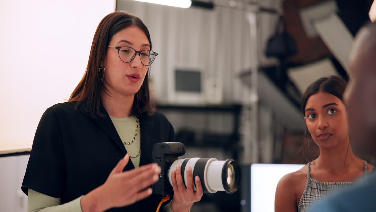 Photographer holding camera talking to colleagues