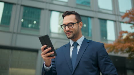 adulto caucásico de 30 años hombre feliz sonriente empresario jefe trabajo en teléfono inteligente moderno de pie al aire libre edificio de oficinas mirar teléfono móvil charlar en línea leer mensajes usar aplicación bancaria negocio electrónico paralaje