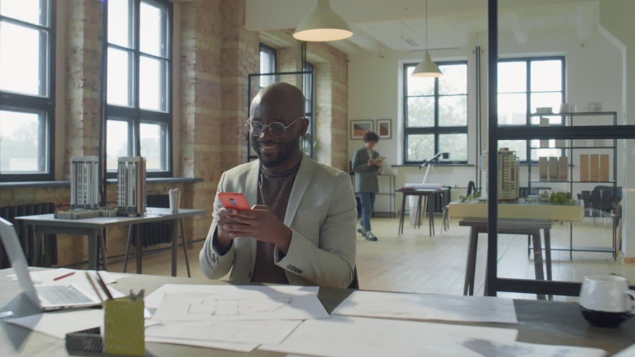 Man Using Smartphone in a Modern Office Setting