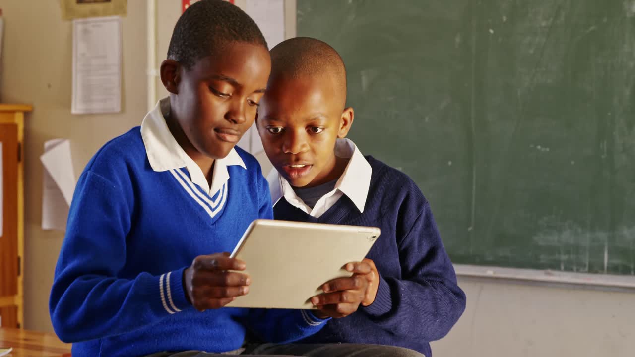 Schoolboys using a tablet during a break at a township school 4k