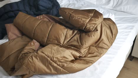 folded puffer jacket on bed