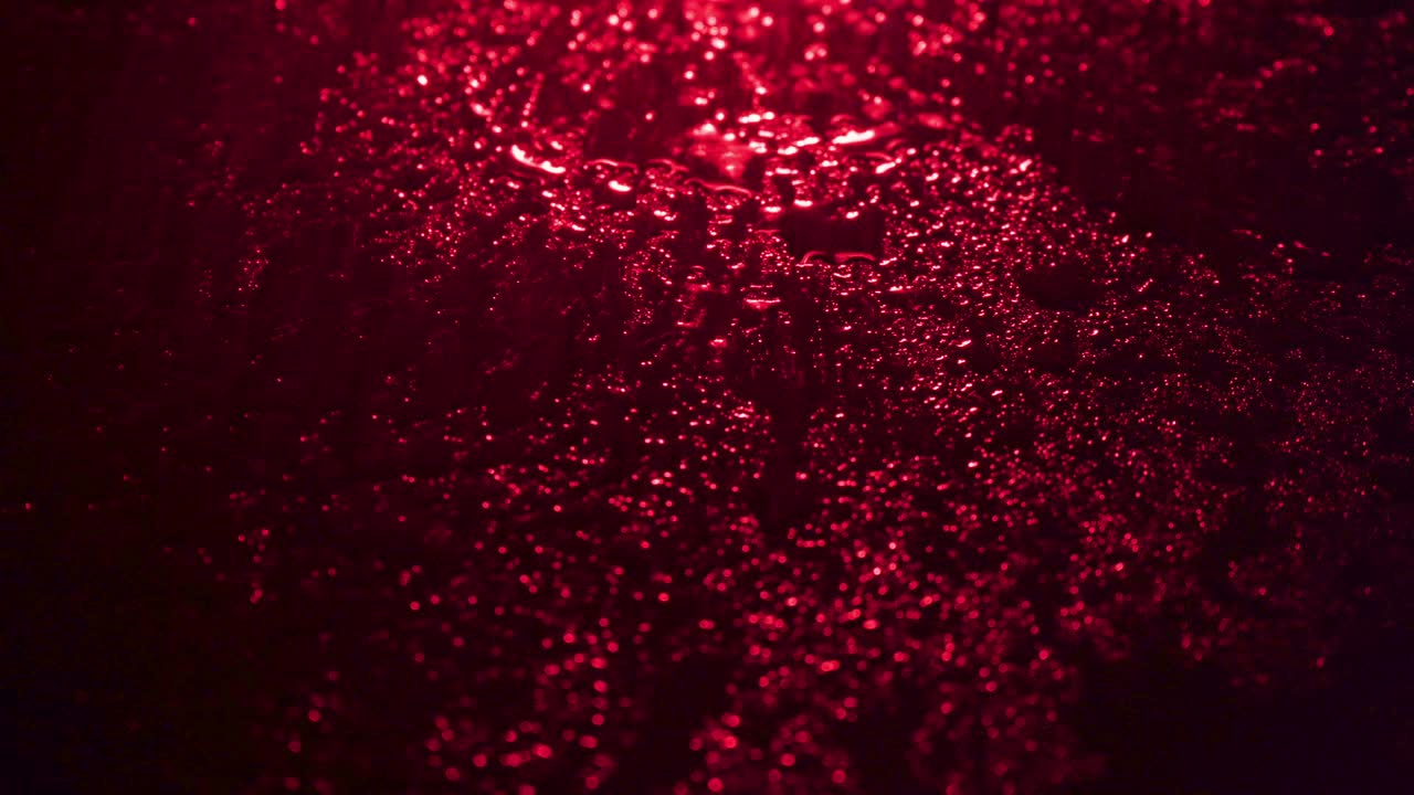 Shooting of wet drops on red background