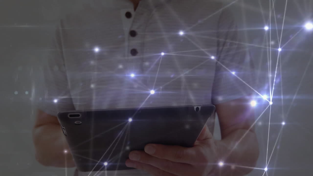Man holding tablet interacting with digital network overlay in tech office, showing data nodes