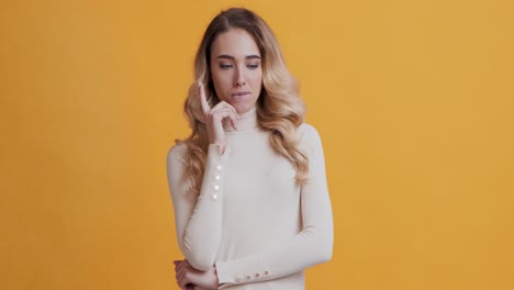 una mujer pensativa con una camiseta beige.