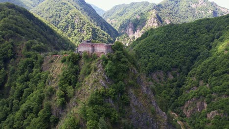 Ruinas-De-La-Ciudadela-De-Poenari-En-La-Cima-De-Una-Montaña-Durante-Una-Mañana-Brumosa,-Histórica-Y-Misteriosa,-Vista-Aérea