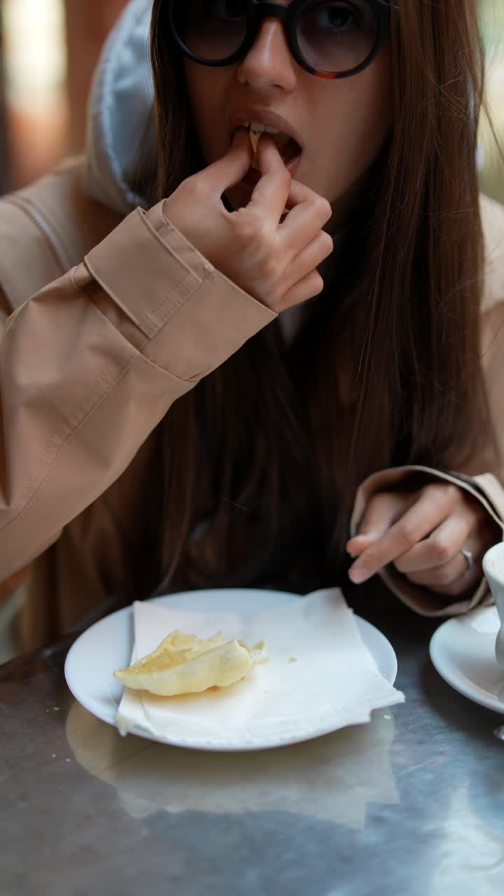 Woman Eating Pastry in a Cafe