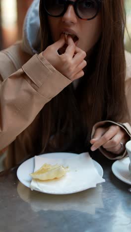 woman eating pastry in a cafe