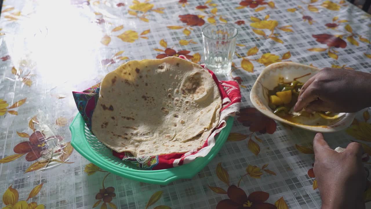una vista cercana de una comida tradicional india mientras un hombre hace su mordida, movimiento lento