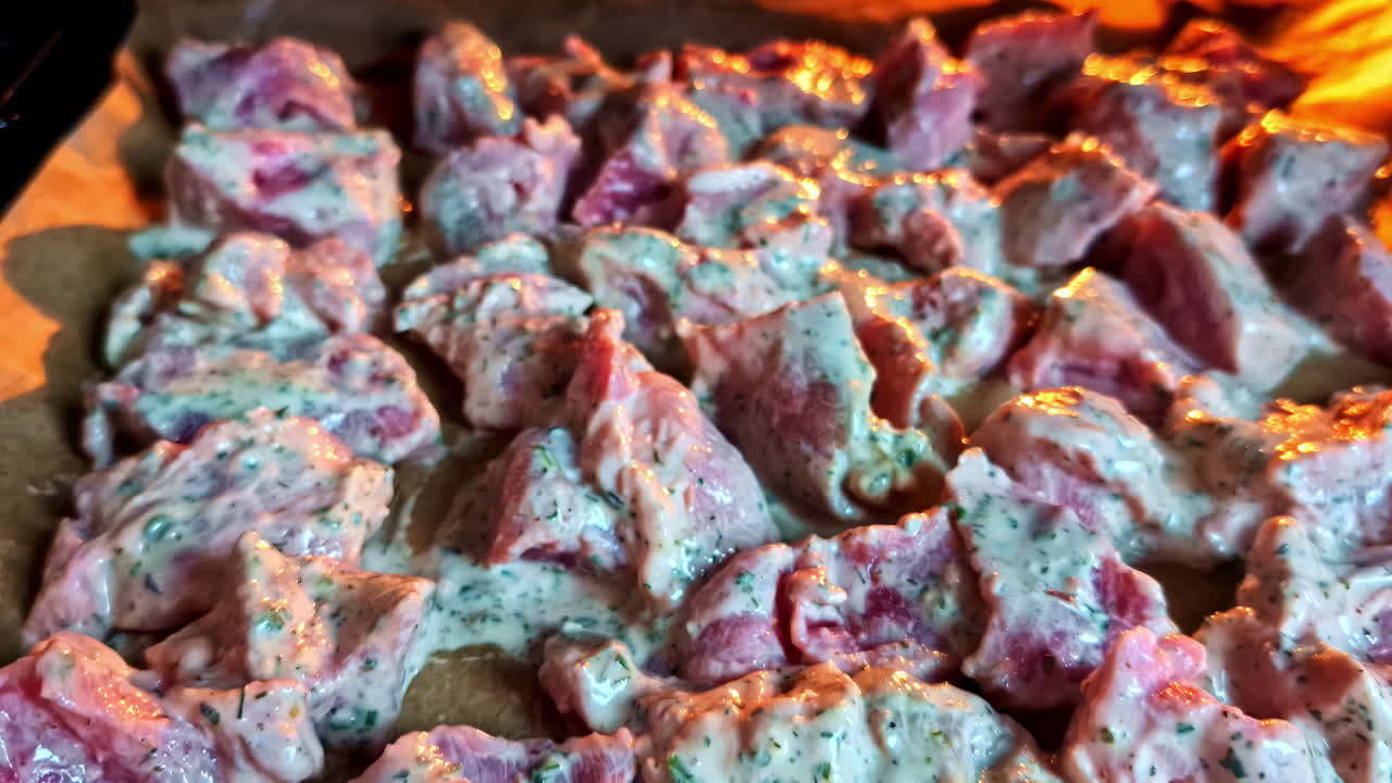 Raw meat marinated in herbs and yogurt placed on tray for baking in stove