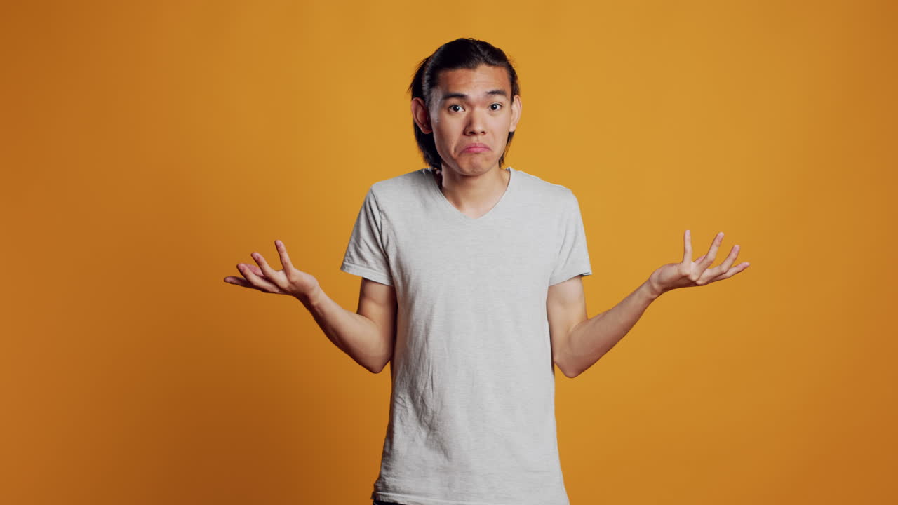 Clueless young person doing i dont know sign in studio