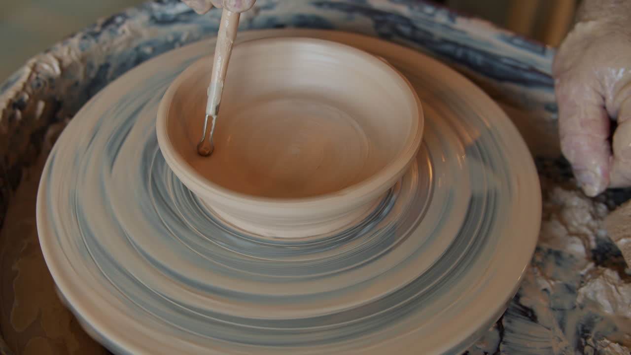 Pottery artist shaping a bowl on a pottery wheel