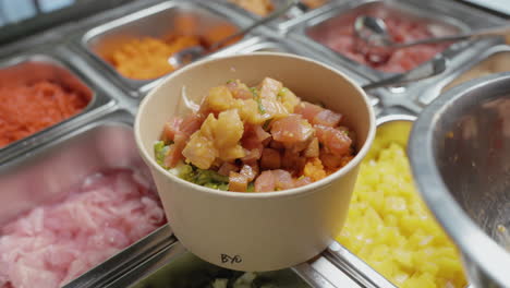 Preparing-Poke-Bowl-Dish-With-Fresh-Diced-Tuna-And-Salmon-Fish-On-Top