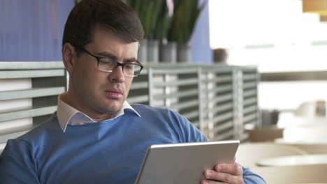 joven empresario trabajando en una tableta en un café