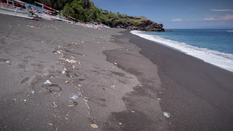 caminando por la orilla arenosa contaminada de la playa de bali en indonesia