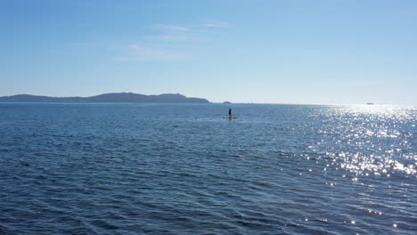hombre en una tabla de paddle de pie tiro aéreo día soleado riviera francesa tranquilo