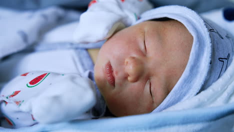 lovely sleeping baby few days old. angelic infant in cap and shirt resting. close up.
