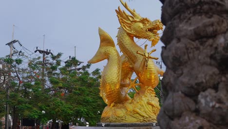 Reveal-shot-of-the-golden-sea-dragon-statue-in-Phuket,-Thailand