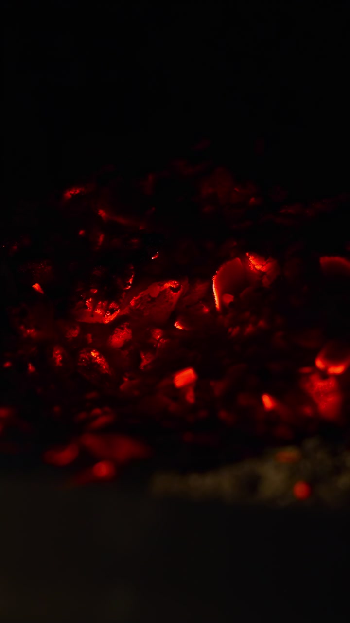 Closeup Ember Glow Inside Fireplace, Dark Mantel And Glass Framing Warm Coals, Slow Flicker And Subtle Smoke