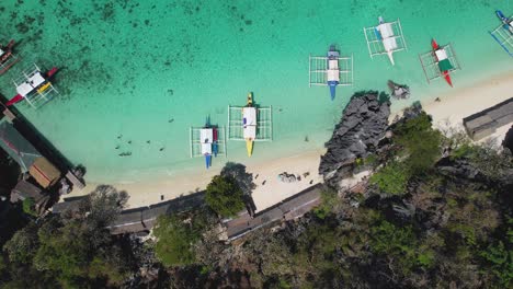 4k drone video looking down at the crystal clear ocean and white sand beach of banal beach in palawan, philippines