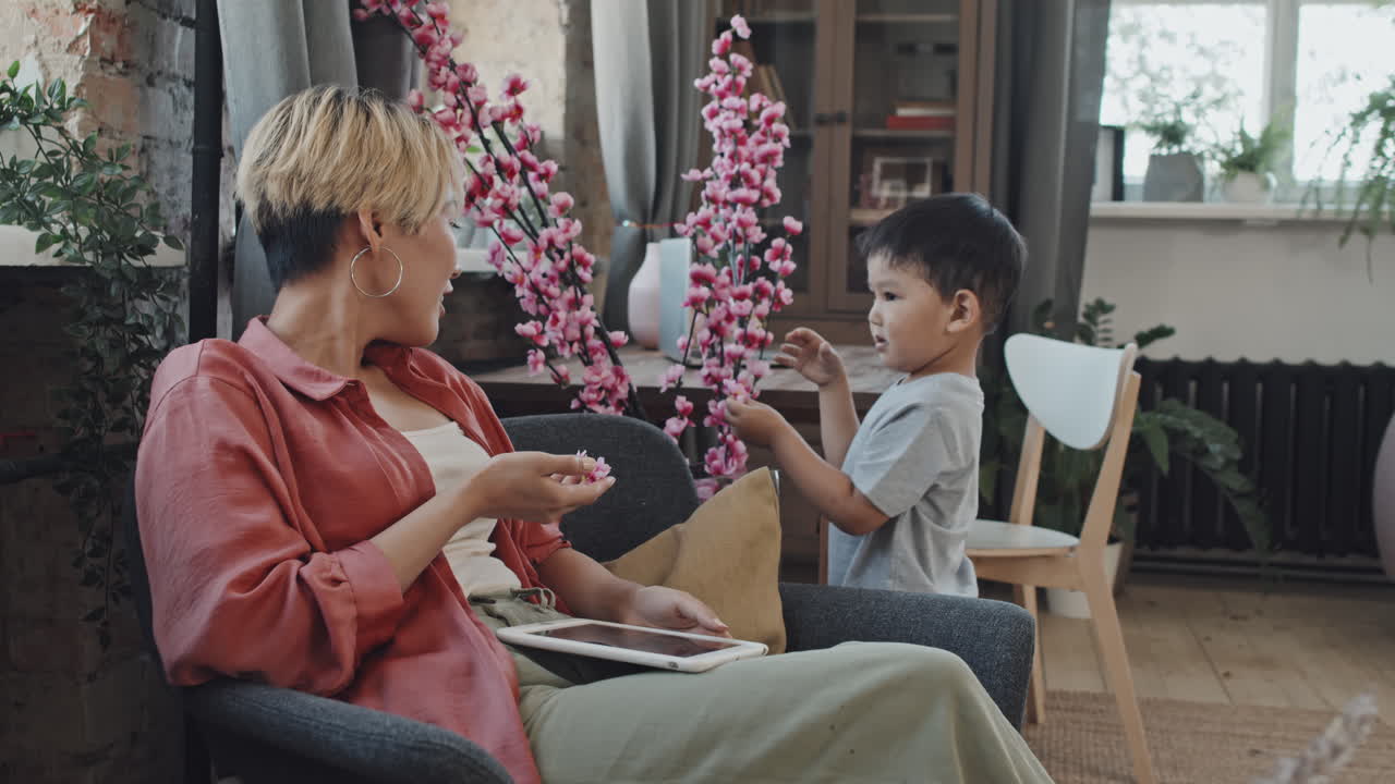 Asian Boy Tearing Off Petals of Artificial Cherry Blossom
