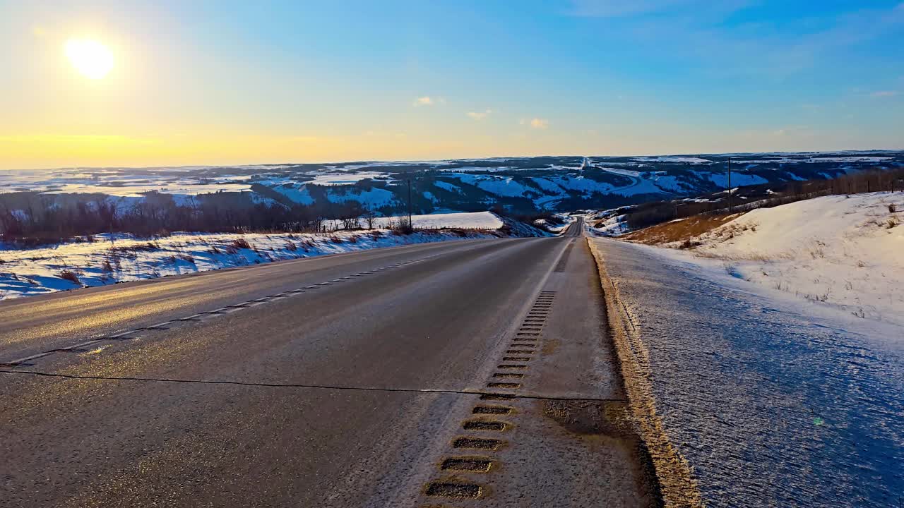 Big Valley Winter highway sunset 4k loop clear day snow melting on the side of the road as vehicles drive by each direction in the shade of the sun ride and sunset
