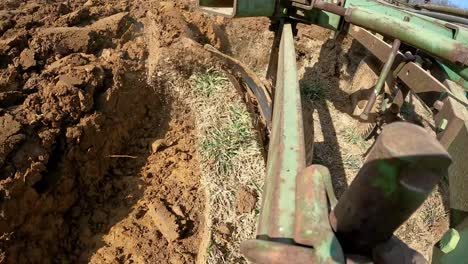 Close-up-of-plow-chisel-turn-the-soil-while-Farmer-prepares-field-for-planting-in-early-spring-in-Midwest